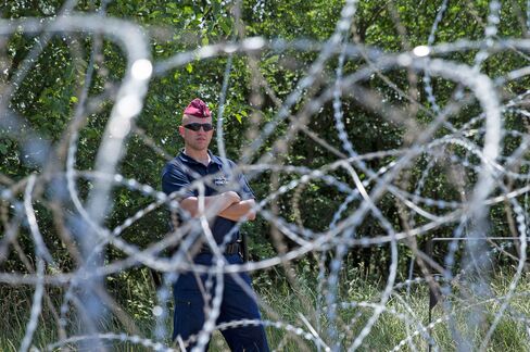 A Hungarian soldier stands guard on the country’s border with Serbia in an effort to manage refugees, in Szeged, Hungary, on July 16, 2015.