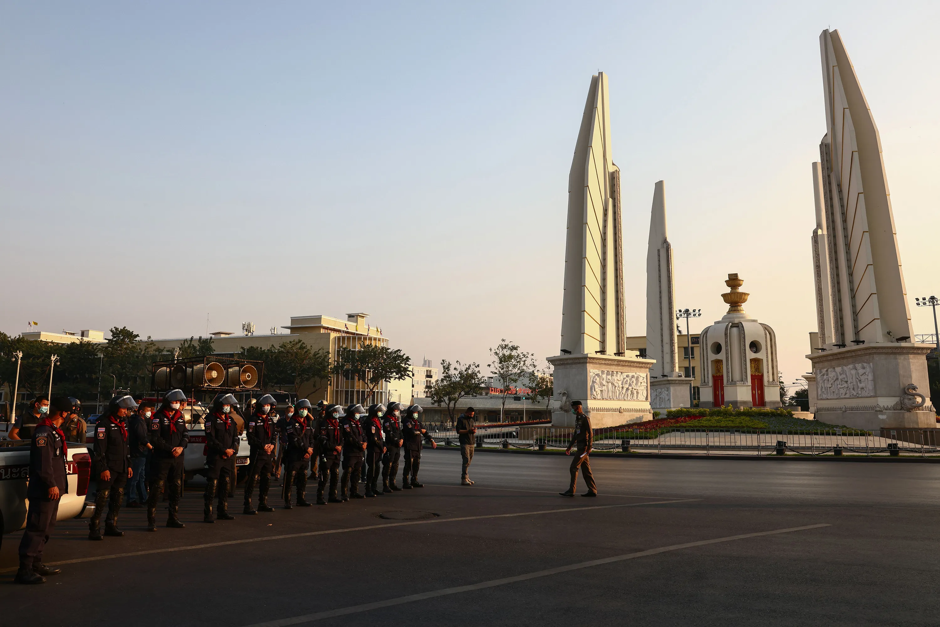 Riot police stand guard as pro-democracy protesters gather by the Democracy Monument for an anti-government rally in Bangkok on Feb. 20.
