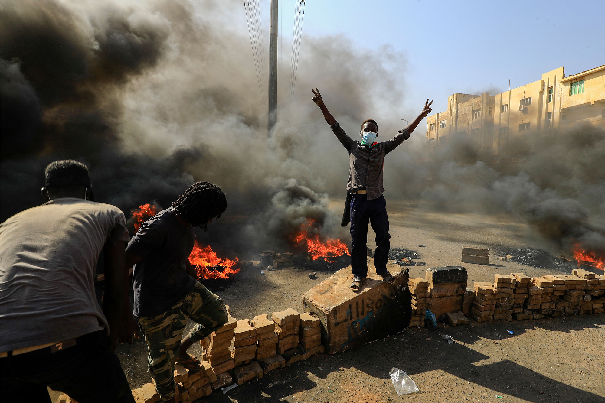 Sudanese demonstrators burn tires and place brick to block a road in Khartoum, on Oct. 25.&nbsp;