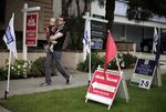 A man walks past open-house signs in front of condominiums for sale in Santa Monica, California.