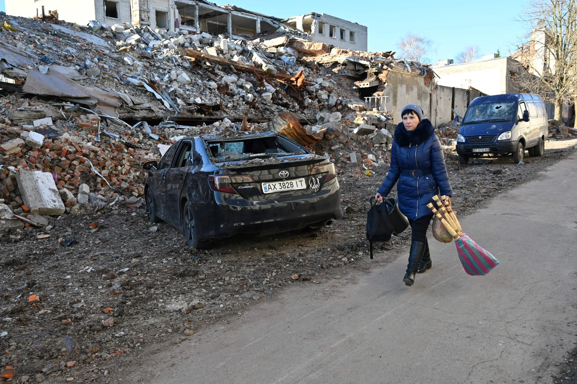 A resident walks past a destroyed building following a C-300 missile strike on the Ukrainian city of Kharkiv on March 31.