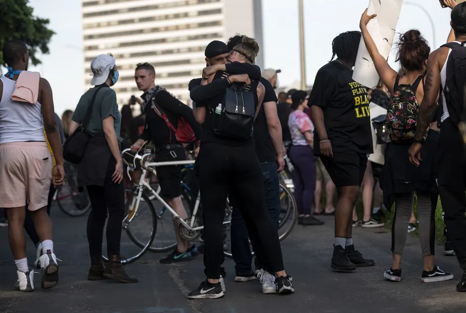 People embrace after a tanker truck drove into protesters on the I-35W bridge on May 31 in Minneapolis.