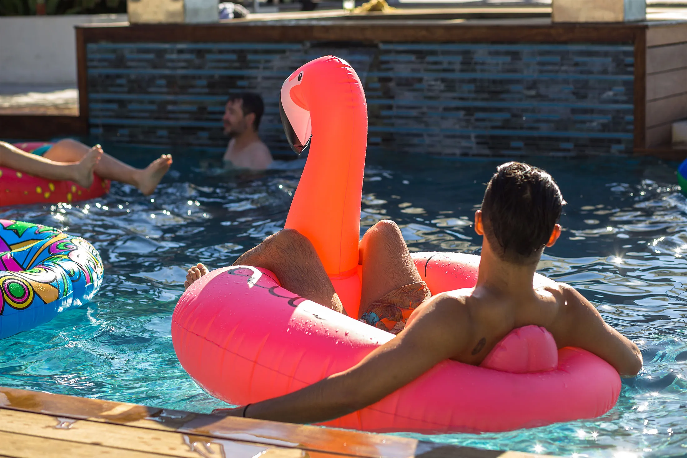 Man in Flamingo Shaped Pool Float