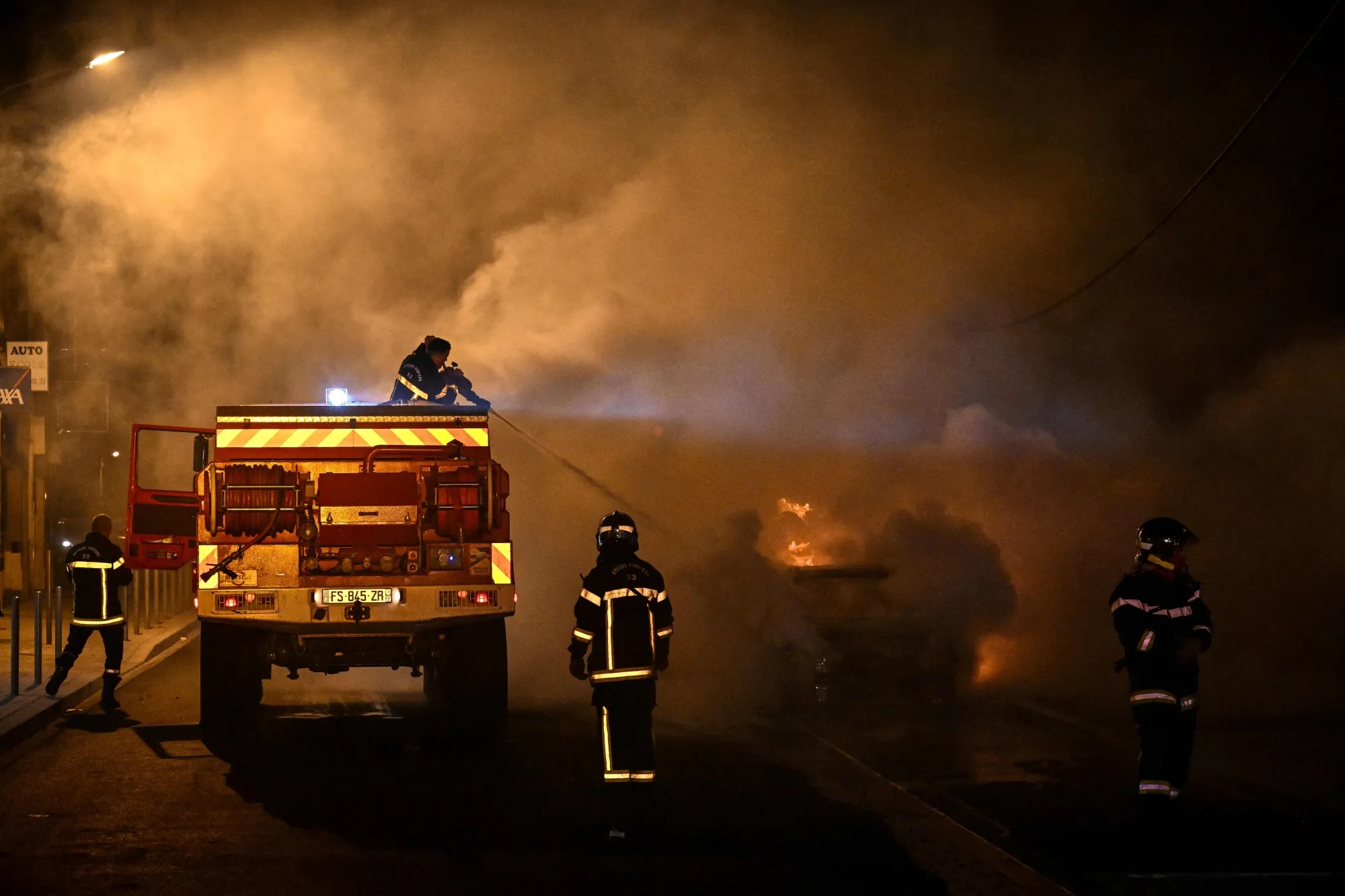 French firefighters put out the flames of a burning car in Floirac,&nbsp;France on June 29.