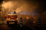 French firefighters put out the flames of a burning car in Floirac, France on June 29.