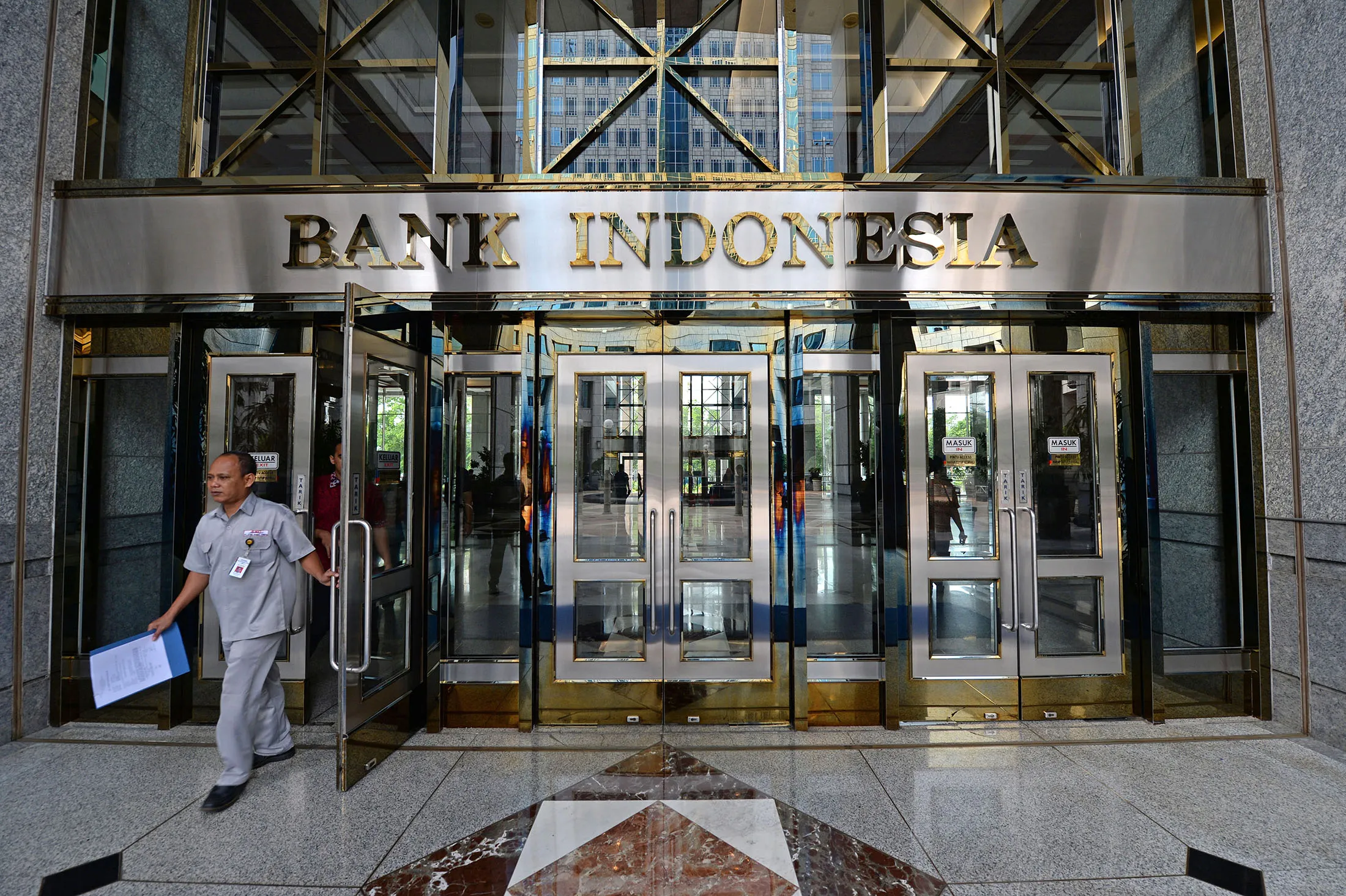 A sign sits above the entrance to the Bank Indonesia in Jakarta, Indonesia, on Tuesday, Nov. 17, 2015. Indonesia's central bank cut the primary reserve requirement for lenders while keeping its main interest rate unchanged, seeking to provide some support to a faltering economy without undermining the currency.
