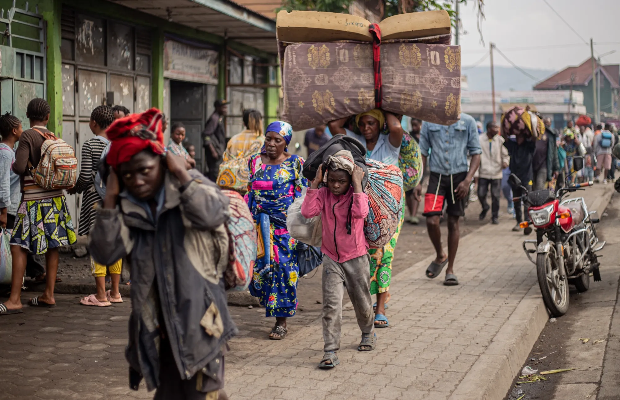 Residents carry their belongings as they flee from Kibati, towards Goma, on Jan. 26.