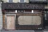 Lenox Lounge in 2013, closed and with brown paper in windows and boarded up doors, neon sign down