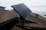 Juan Moedano, an installer for Stellar Solar, carries a solar panel during installation at a home in Encinitas, Calif.