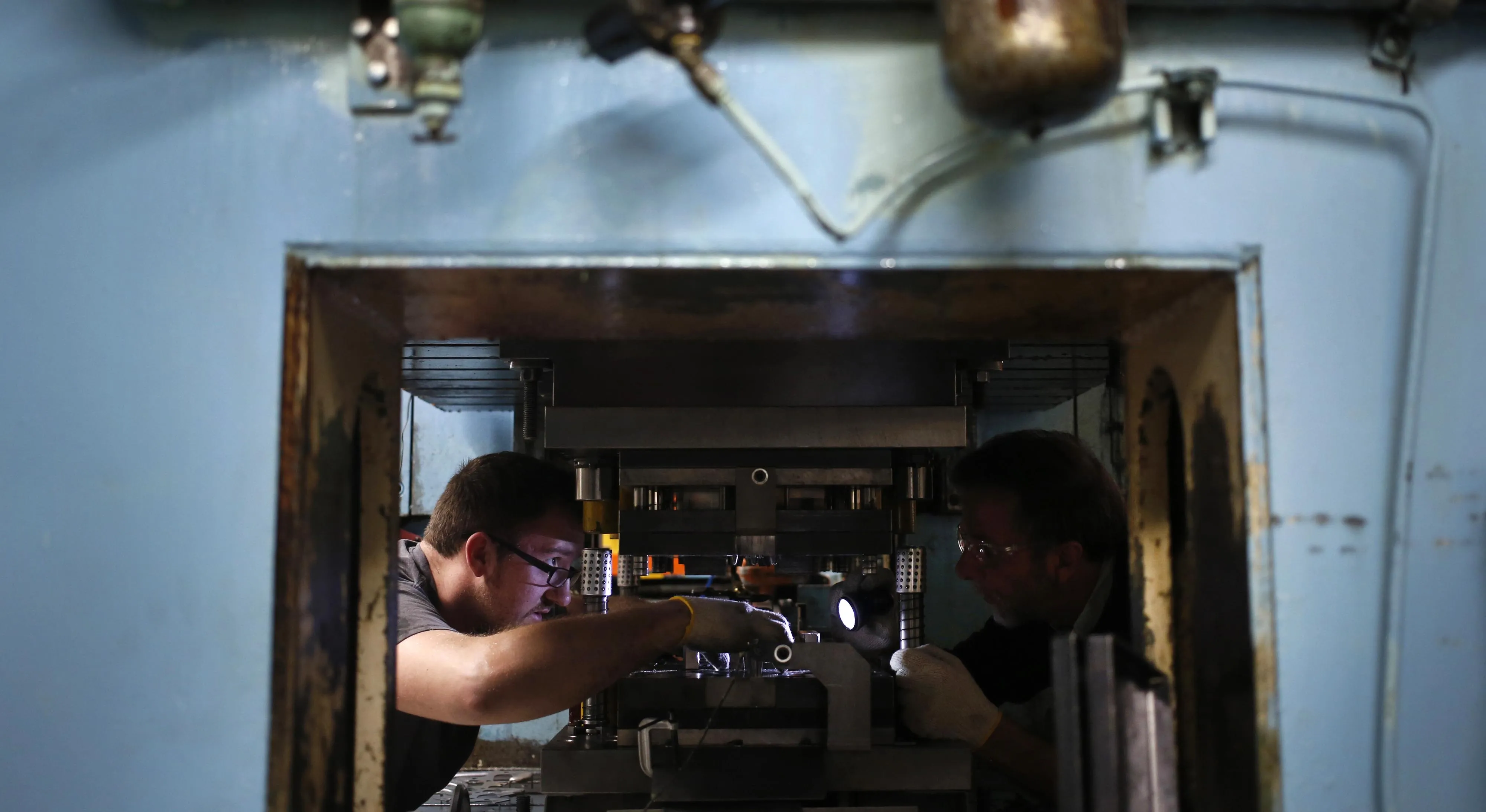 Factory technicians repair an automated production press at a tool works facility in Richmond, Kentucky.