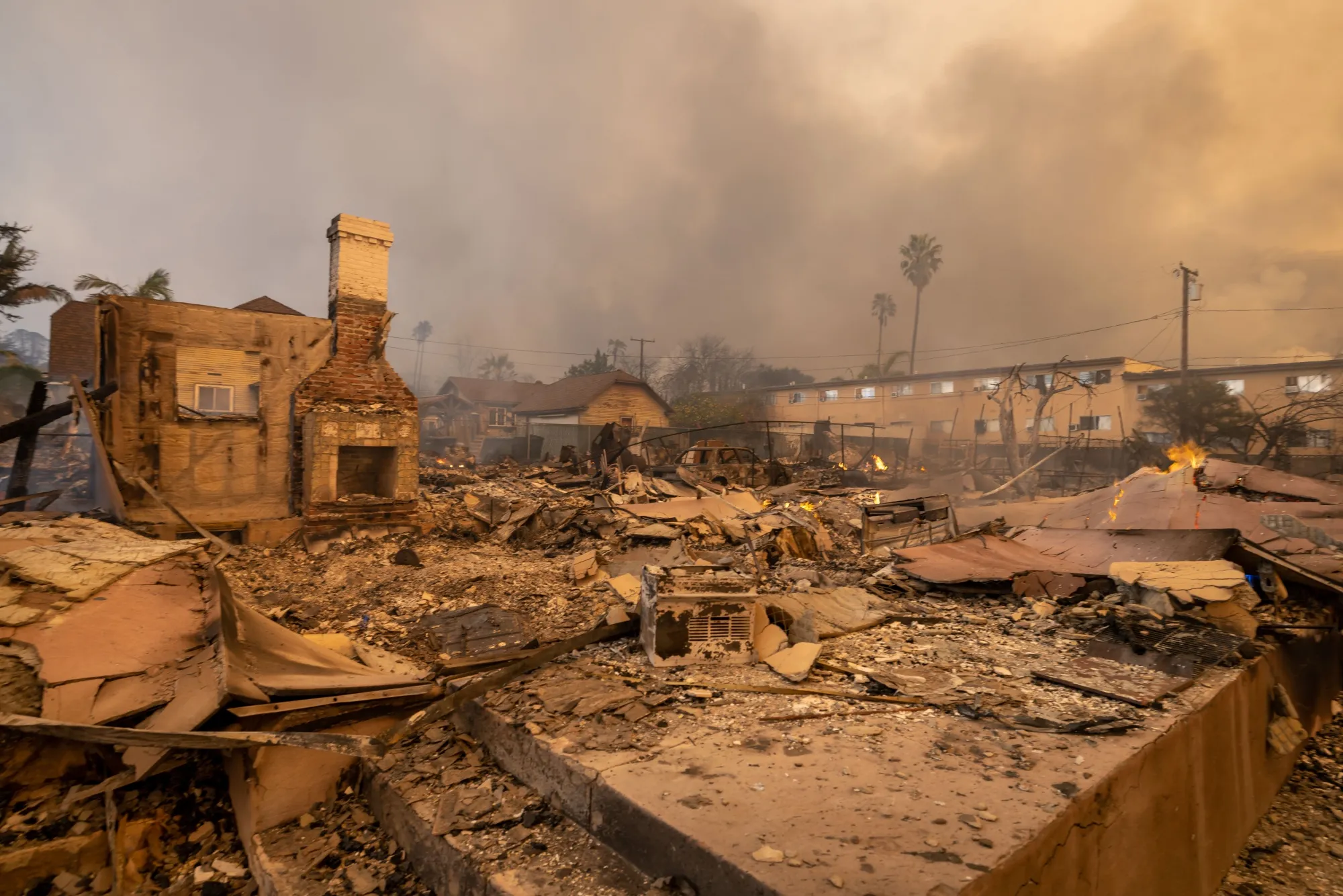 A chimney remains standing next to a destroyed home during the Eaton Fire in Altadena.