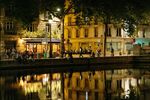 Buildings lit by street lights are reflected in the Canal Saint-Martin in Paris, France.