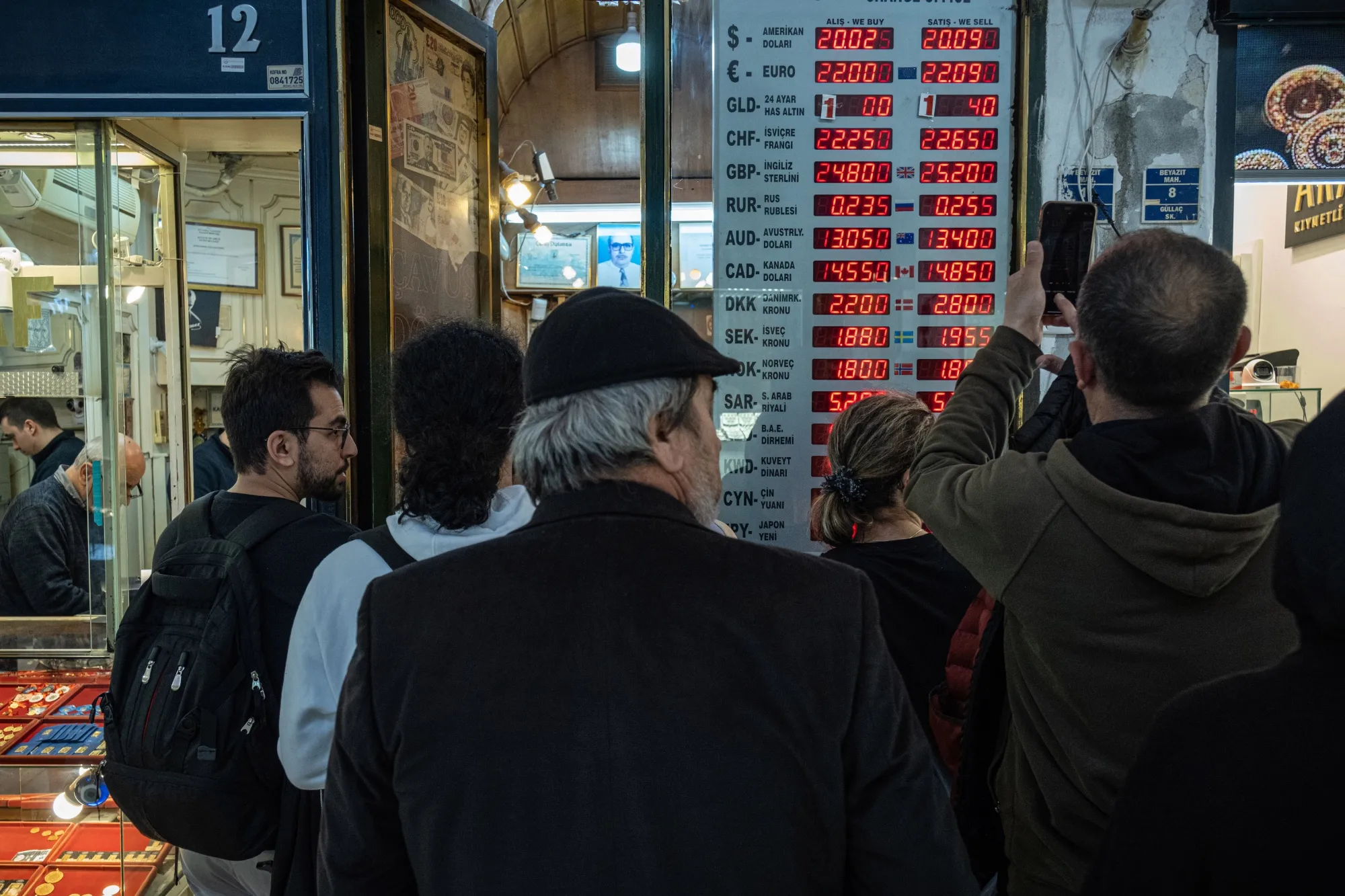 Customers queue to exchange money at a foreign currency exchange bureau in Istanbul, Turkey.