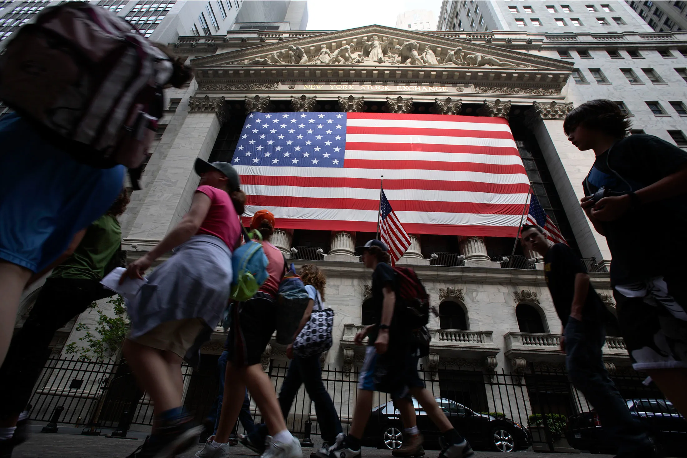 Pedestrians walk past the New York Stock Exchange in New York
