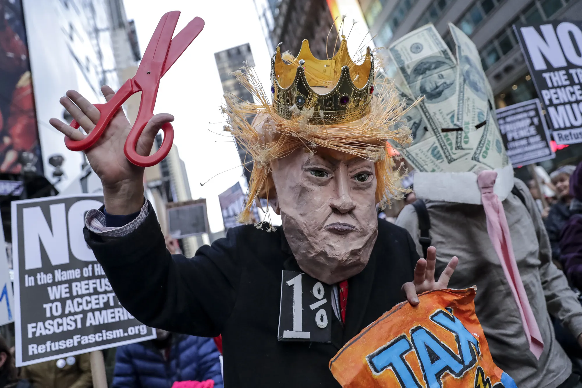 Demonstrators dressed in the likeness of U.S. President Donald Trump and 100 dollar banknotes participate in "The Trump/Pence Regime Must Go" rally in the Times Square area of New York, U.S., on Saturday, Nov. 4, 2017.&nbsp;