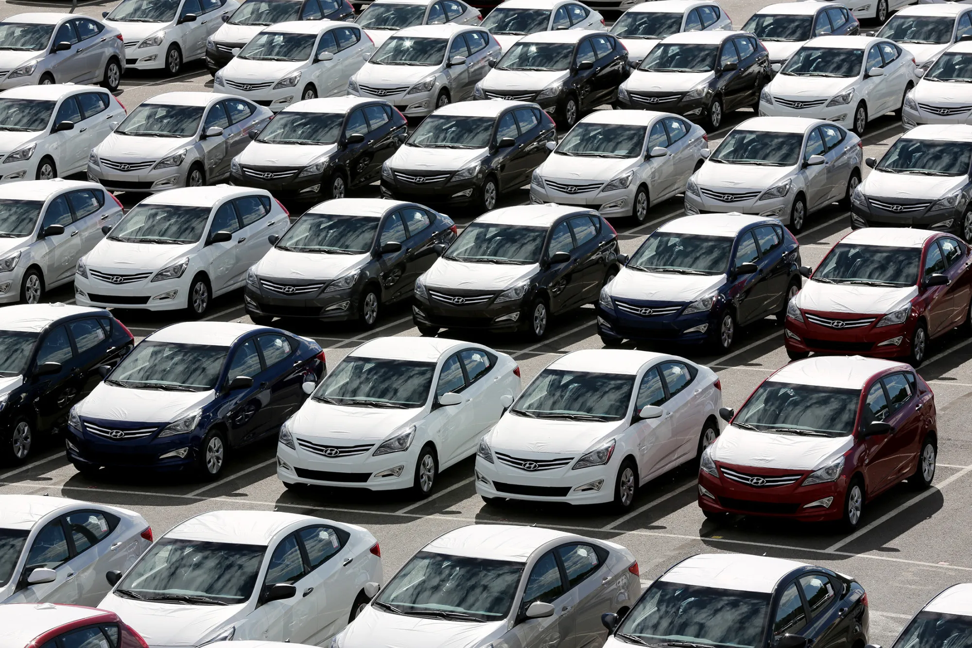 Completed Hyundai Solaris vehicles sit ahead of distribution outside the Hyundai Motors Corp. automobile plant in St Petersburg.
