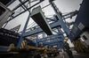 A dock worker directs the loading of shipping containers onto CMA CGM SA's Benjamin Franklin container ship docked at the Guangzhou Nansha Container Port in Guangzhou, China, on Monday, Feb. 1, 2016. The Benjamin Franklin is the largest container ship ever to have docked at a U.S. port.
