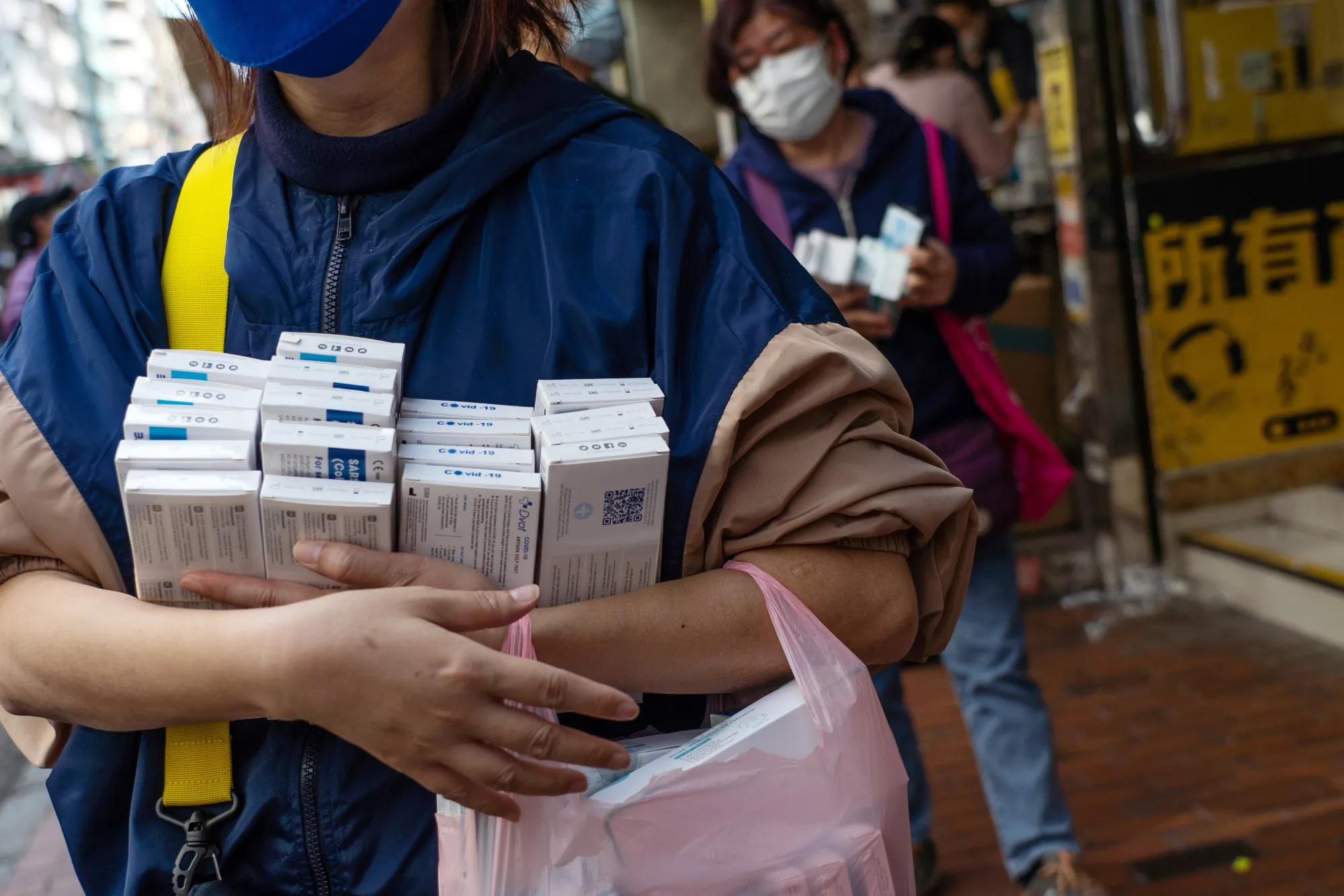 Customers hold newly-purchased Covid-19 rapid antigen test kits in Hong Kong.