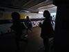 Passengers wait at Clapham Junction station in London on Aug. 9.