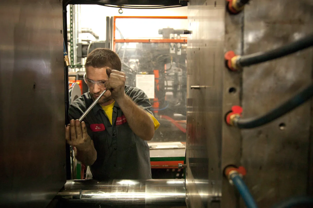 An operator specialist sets a new mold in an injection molding machine at the Miller Felpax Corp. parts manufacturing facility in Winona, Minnesota, on March 20, 2013. Photographer: Ariana Lindquist/Bloomberg