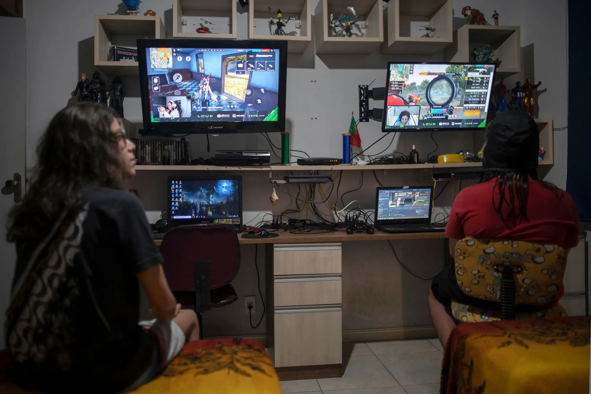 Boys watch professional players play Free Fire in Rio de Janeiro.