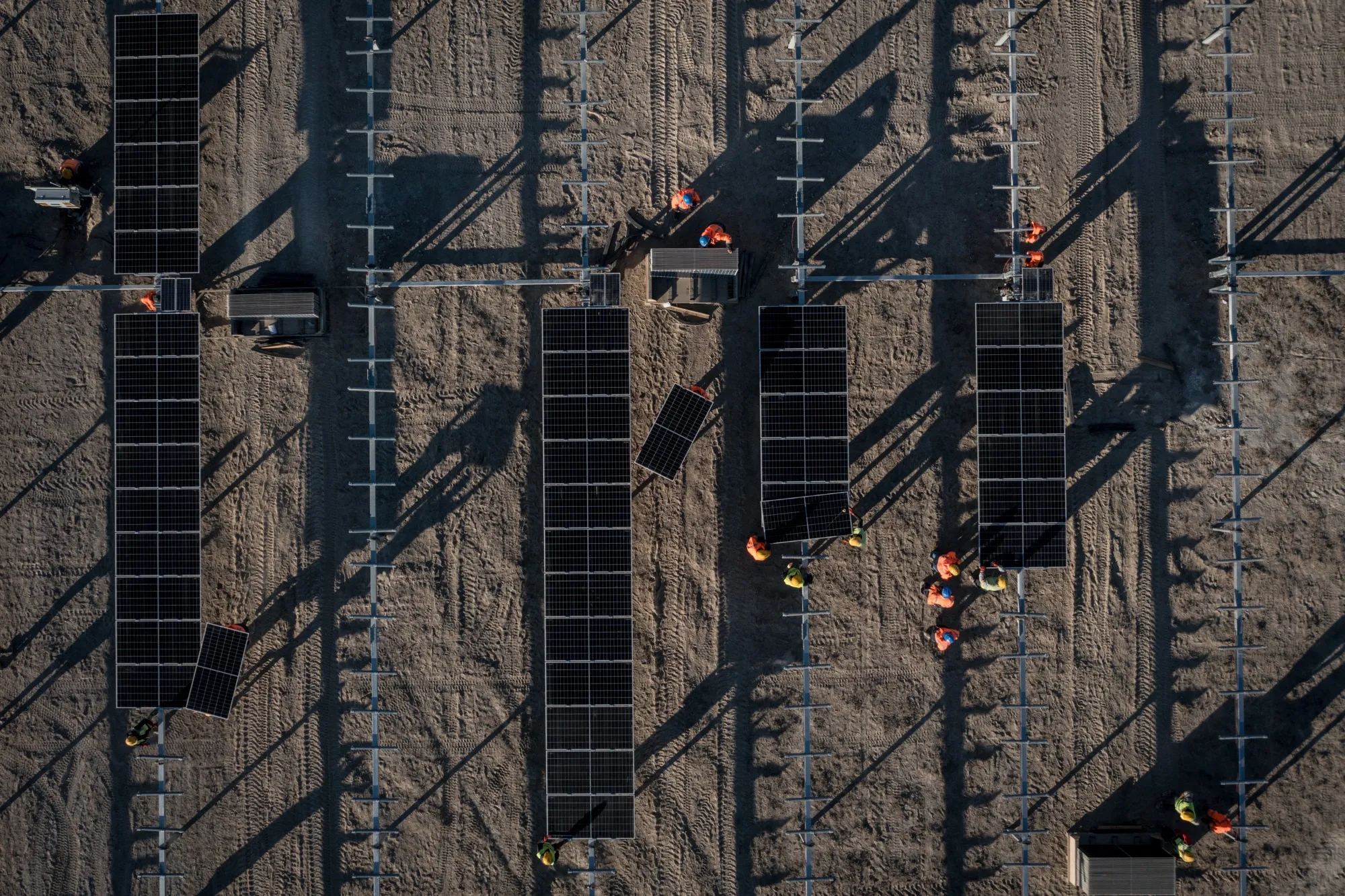 Employees install new solar panels on a solar farm.&nbsp;