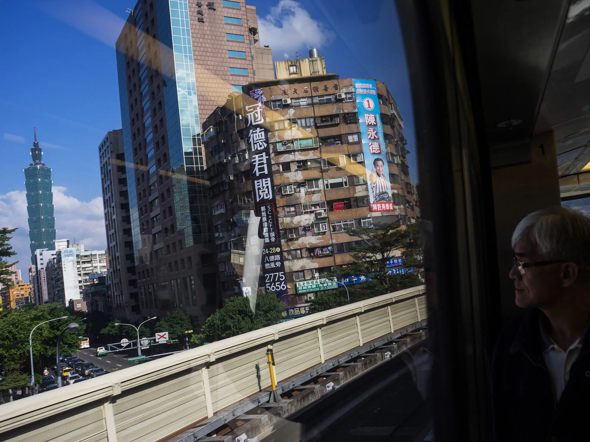 A passenger looks out at the Taipei 101 building