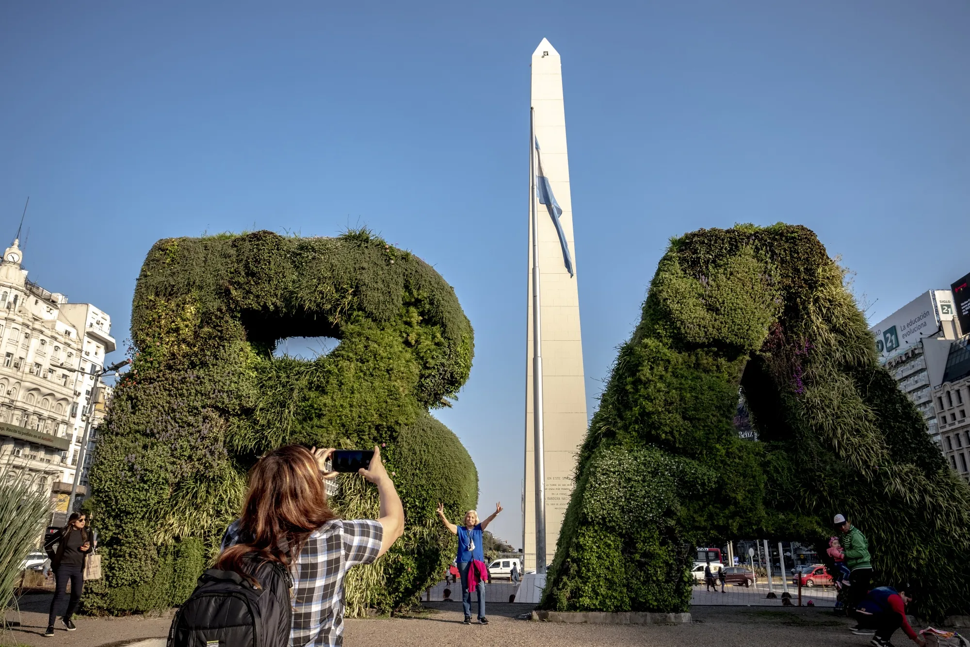 Tourists take photos in front of the Obelisk in Buenos Aires.