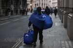 A worker carrying laundry bags in the City of London, UK, on Tuesday, Feb. 14, 2023. UK wages rose quicker than expected at the end of 2022, heaping pressure on the Bank of England to deliver another interest-rate increase next month.