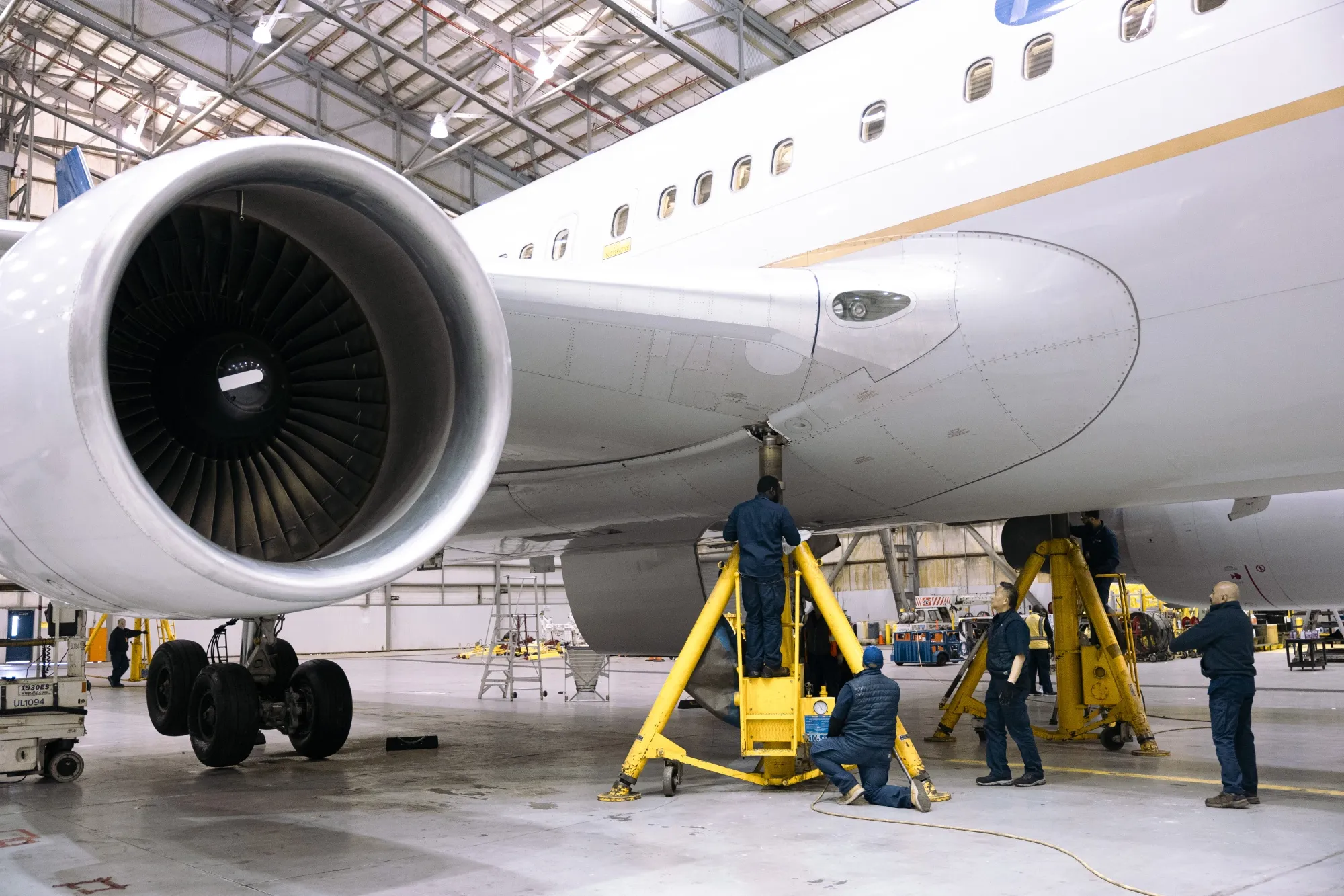 Workers install parts on&nbsp;a Boeing airplane in a maintenance hanger.