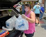 Jolene Balatgek, loads food into the back of a person's car. During a food distribution at the Salem United Methodist Church in Shoemakersville, PA on July 15, 2020.&nbsp;
