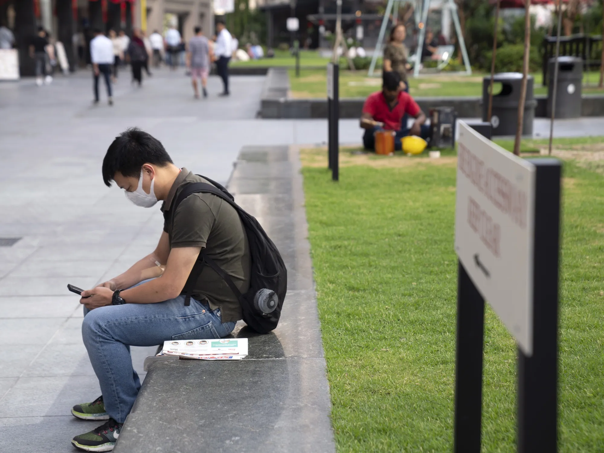 A man wearing a protective mask looks at a smartphone&nbsp;in Singapore, on Jan. 31.