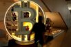 A worker walks past a Bitcoin display in San Salvador, El Salvador. 