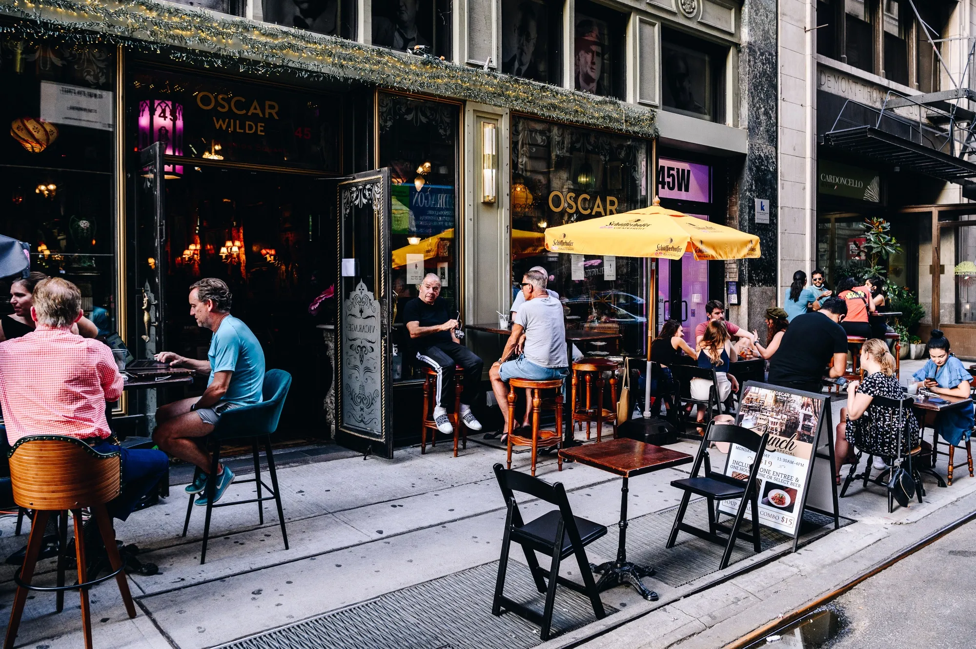 People sit outside during happy hour at the Oscar Wilde bar in New York, U.S., on&nbsp;June 10.