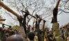 Trainee soldiers for a new unified army raise wooden rifles above their heads while attending a reconciliation program run by the United Nations Mission in South Sudan at makeshift barracks in Mapel on Jan. 31.
