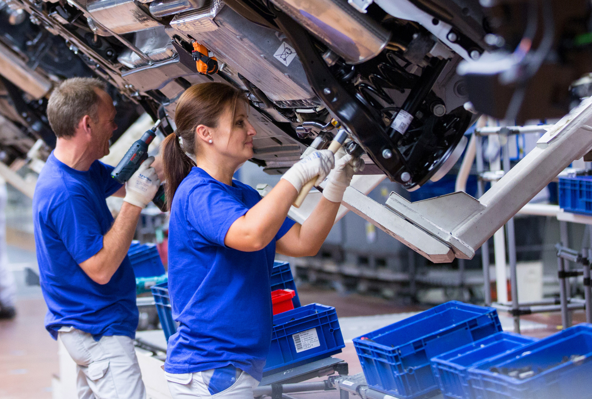 Employees work on Volkswagen e-Golf electric automobiles on the assembly line inside the Volkswagen AG (VW) factory in Wolfsburg, Germany, on Friday, May 20, 2016. Volkswagen AG agreed to raise German workers' pay after labor leaders vowed that employees wont foot the multi-billion-euro bill to resolve its diesel-emissions scandal.
