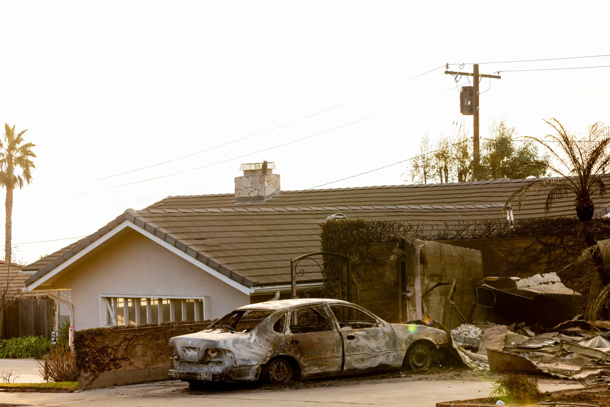 A home destroyed by the Eaton Fire next to an intact home in Pasadena, California.