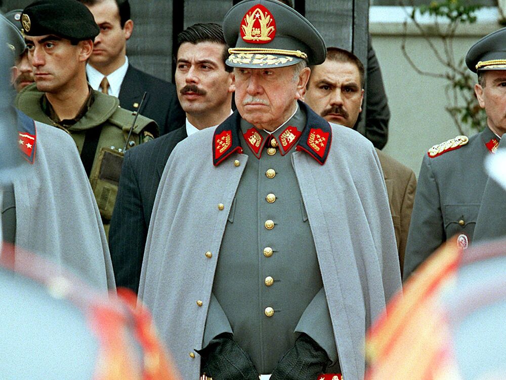 Augusto Pinochet listens to a military band playing before his residence in Santiago on Sept. 11, 1997.