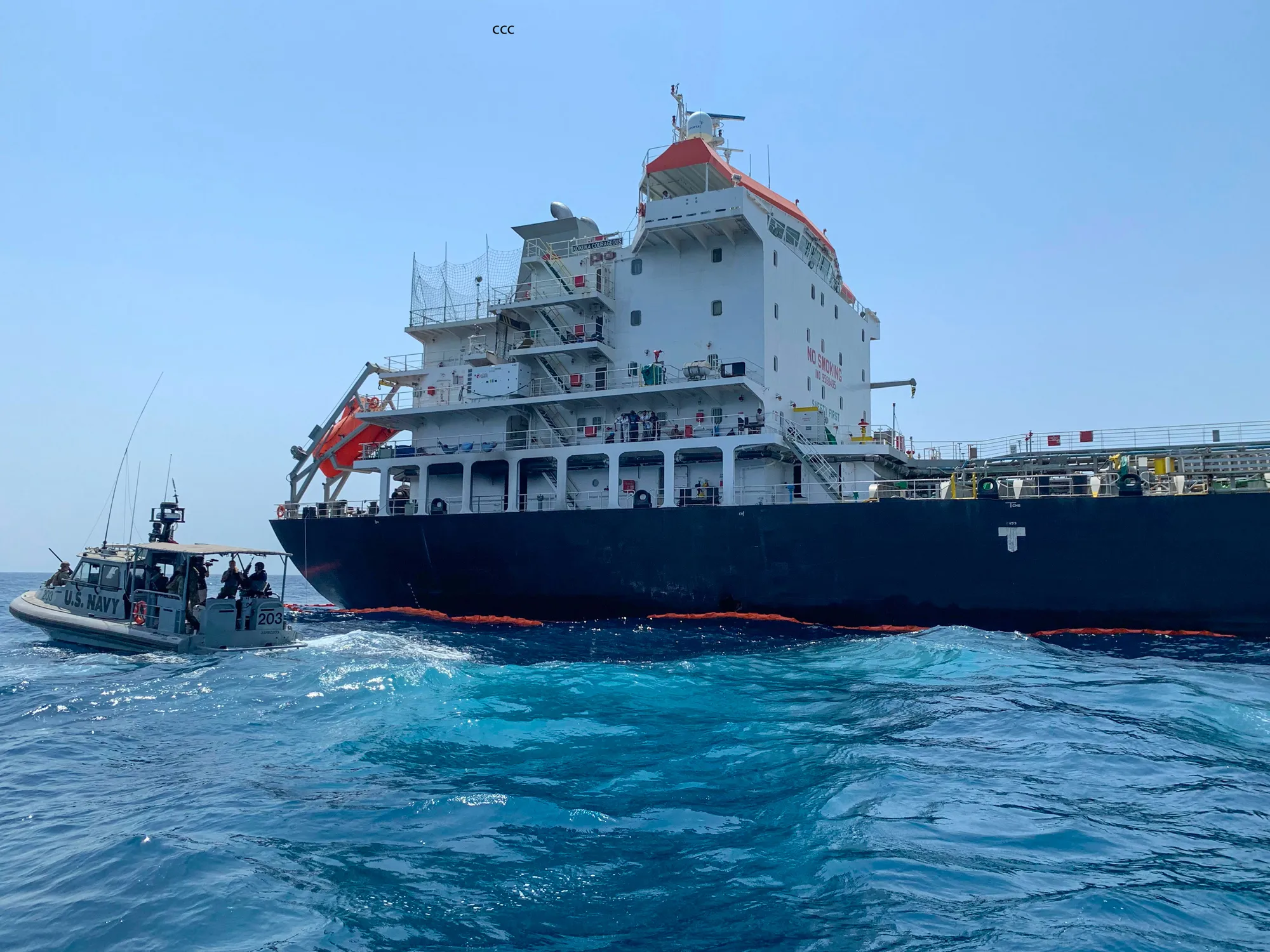 A U.S. Navy vessel guards the Japanese oil tanker Kokuka Courageous in the Gulf of Oman.
