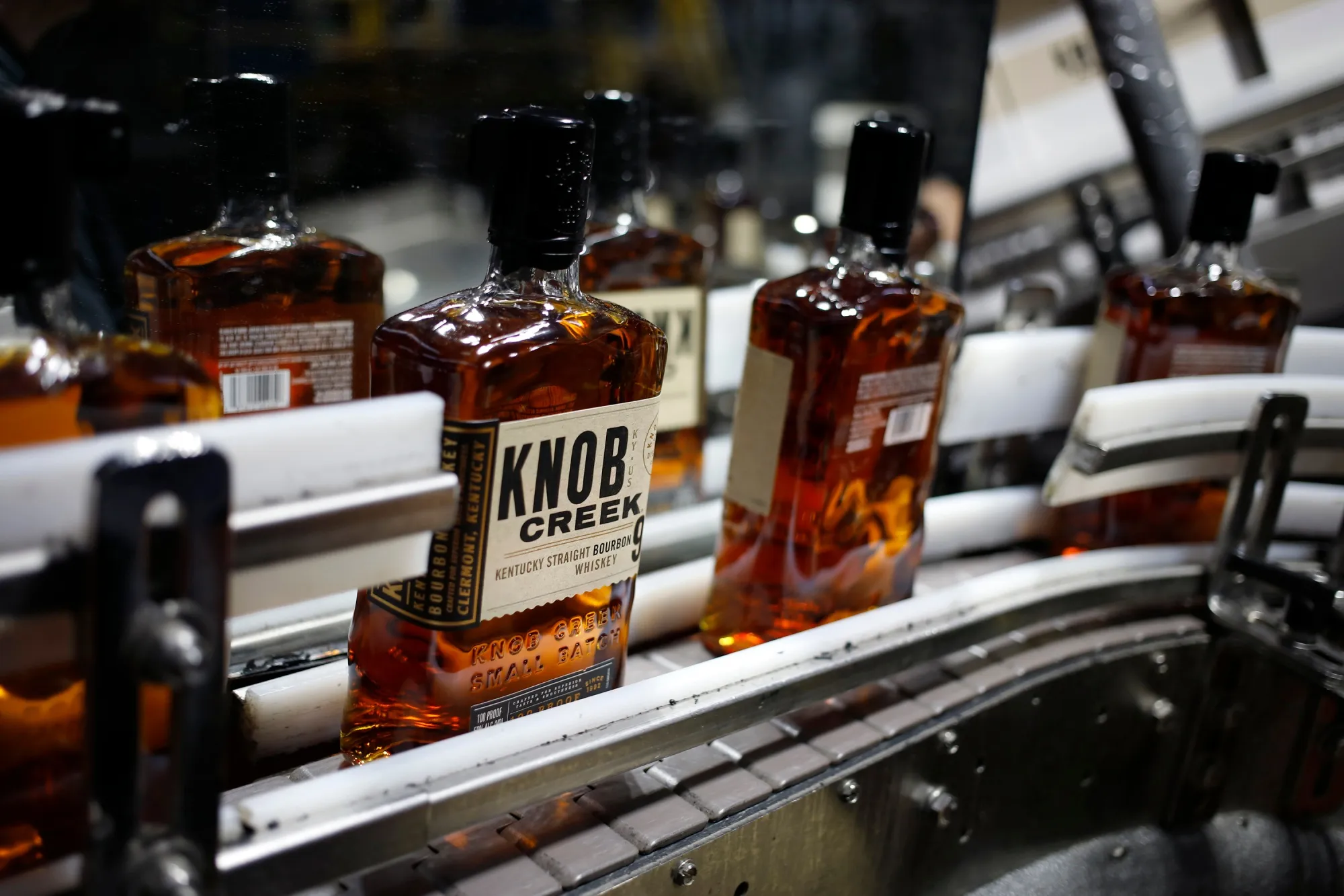 Bottles of Knob Creek brand bourbon whiskey on a conveyor belt in Clermont, Kentucky.