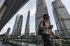 A pedestrian walks along an elevated walkway in the Lujiazui Financial District in Shanghai, China, on Monday, Sept. 4, 2017. The Chinese central bank's tight leash on liquidity is straining the bond market, with the benchmark sovereign yield climbing to near the highest level since April 2015.