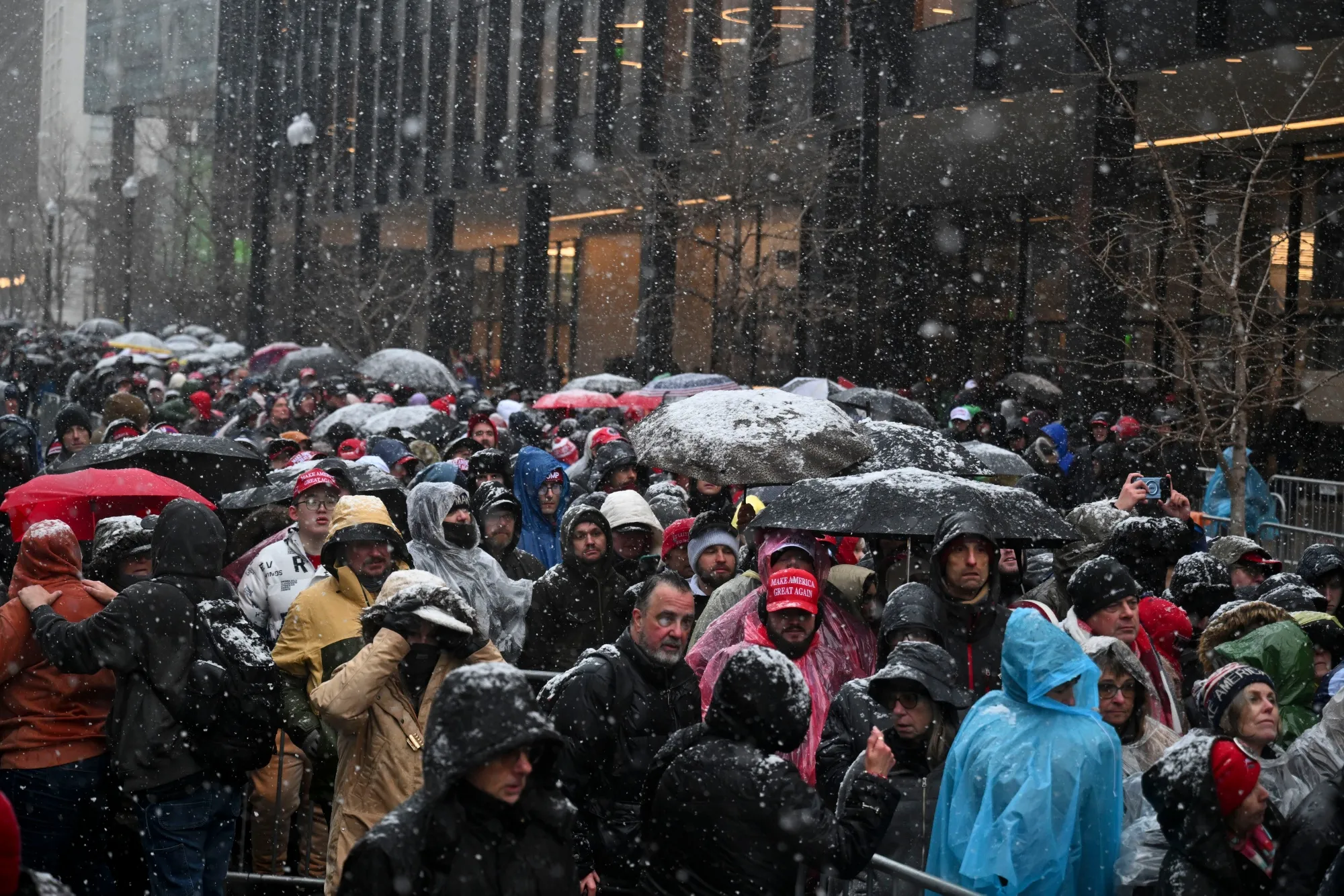 Attendees stand in the snow outside a rally with President-elect Donald Trump at Capital One Arena ahead of the 60th presidential inauguration in Washington, DC, on Jan. 19.
