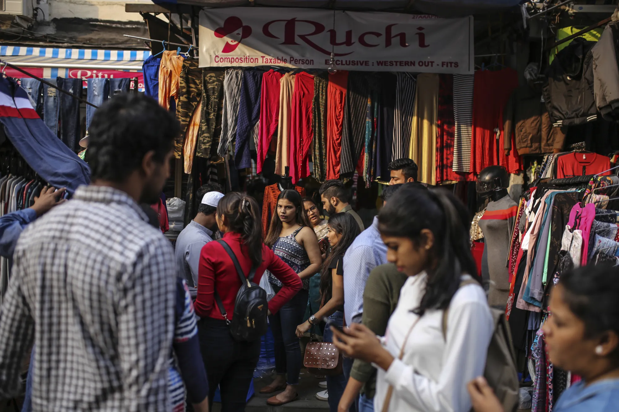 Shoppers and pedestrians walk past roadside stalls in Mumbai, India, on Friday, Dec. 15, 2017. India's inflation surged past the central bank's target, bolstering a view that interest rates may rise earlier than expected and offering little relief to battered bond markets.