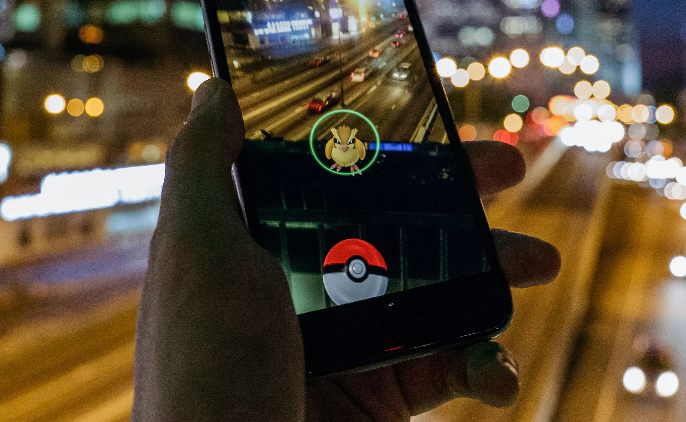 The Pidgey character of Nintendo Co.'s Pokemon Go augmented-reality game, developed by Niantic Inc., is seen in front of the Hong Kong skyline on a smartphone in an arranged photograph in Hong Kong, China, on Monday, July 25, 2016.
