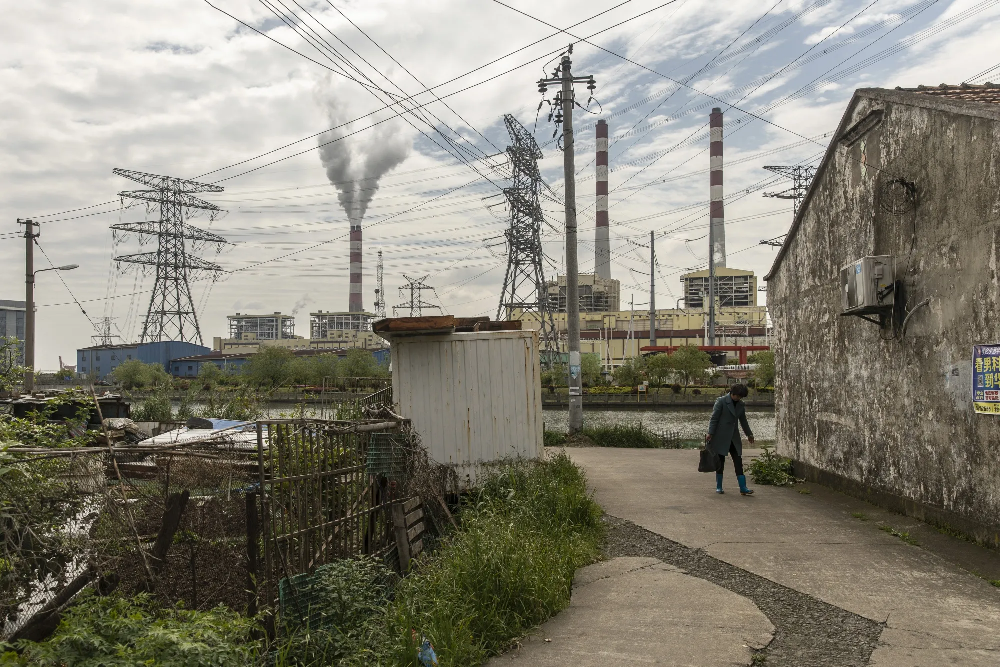 A pedestrian near a coal-fired power station on the outskirts of Ningbo, Zhejiang Province, China.