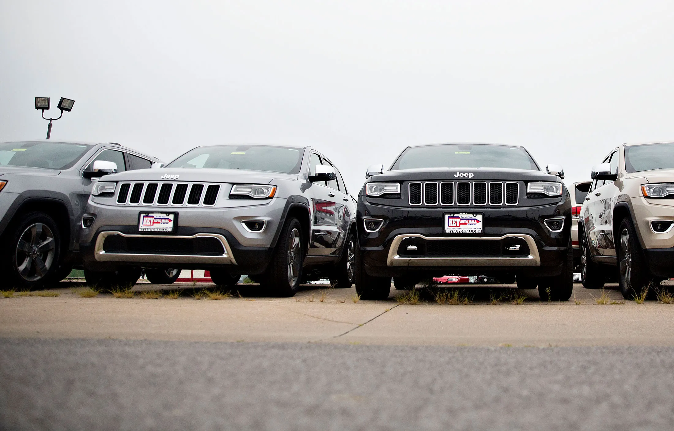 A row of 2015 FCA US LLC Jeep Grand Cherokee vehicles sit on display at the Key Auto Mall car dealership in Moline, Illinois.
