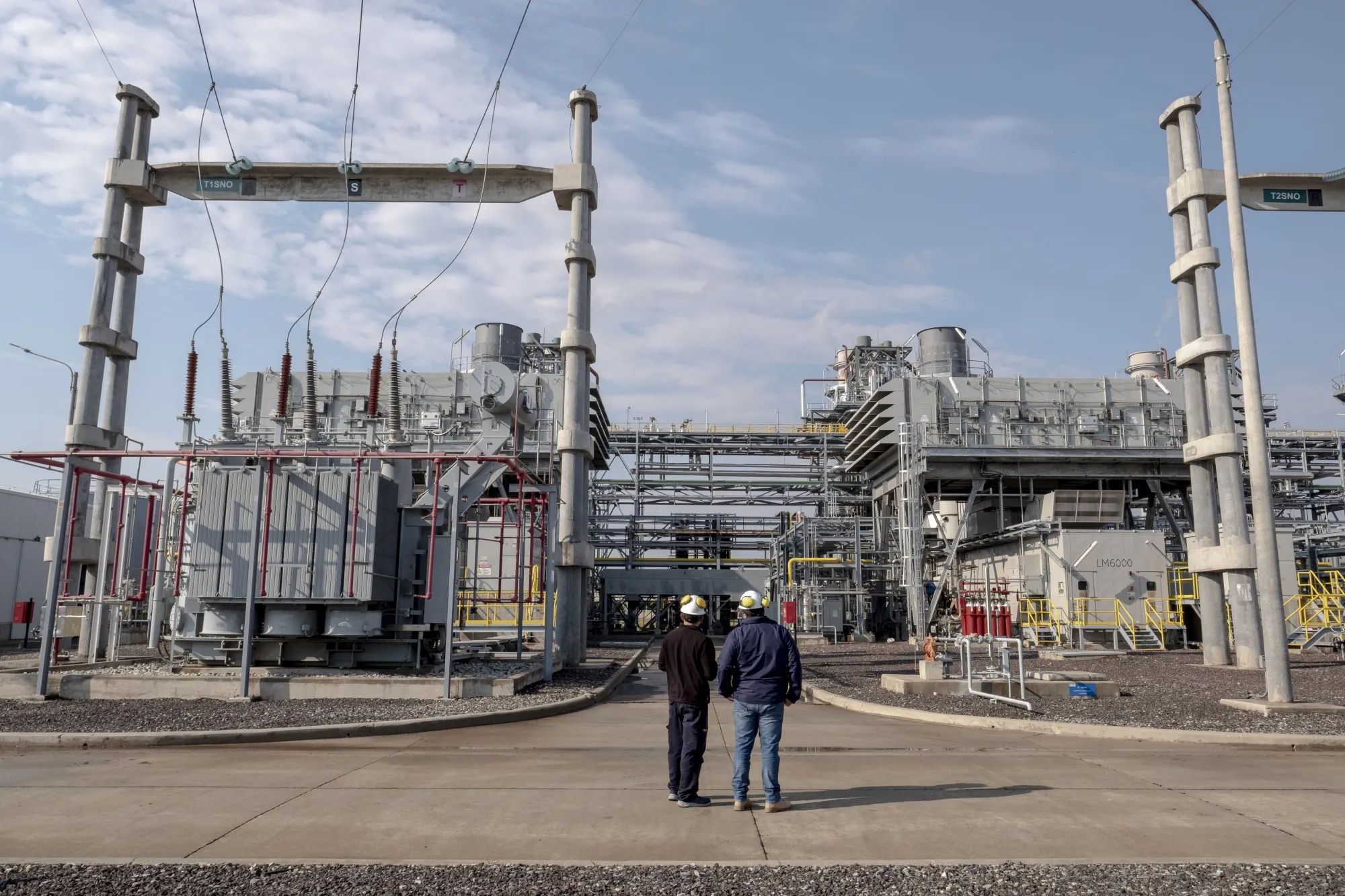 Workers stand in front of the MSU Energy SA General Rojo natural gas plant in General Rojo, Buenos Aires province, Argentina, on Wednesday, July 7, 2021.