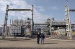 Workers stand in front of the MSU Energy SA General Rojo natural gas plant in General Rojo, Buenos Aires province, Argentina, on Wednesday, July 7, 2021.
