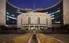 The People's Bank Of China (PBOC) headquarters stand at night in the financial district of Beijing, China, on Monday, March 2, 2015. China's yuan fell to the lowest in more than two years, money-market rates dropped and most stocks advanced after the central bank cut benchmark borrowing costs for the second time in three months amid an economic slowdown.