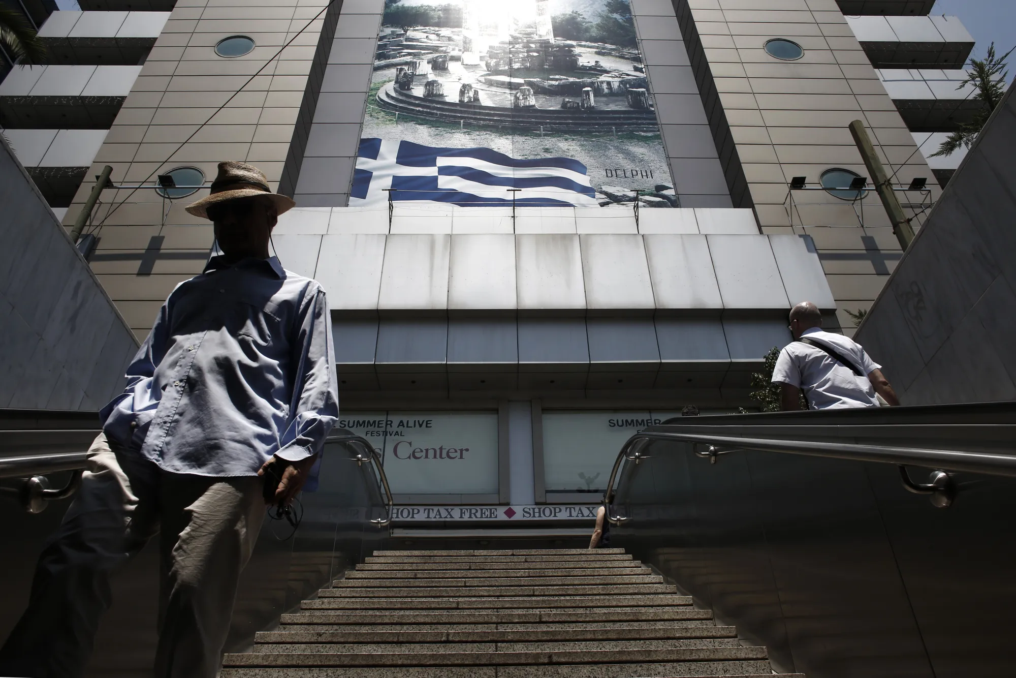 Pedestrians enter a metro station in Athens.